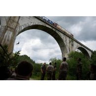 Un soldat polonais descend un viaduc en rappel au passage d'un train à Lunca de Sus, en Roumanie.