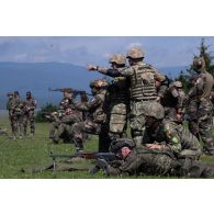 Des soldats du 35e régiment d'infanterie (RI) tirent aux fusil d'assaut AK-47 et RPK sous la supervision de leurs homologues roumains sur le champ de tir à Lunca de Sus, en Roumanie.