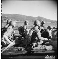 Des membres du groupe de commandos d'Afrique, devenu 5e bataillon de choc, à bord de rubber boats longent les falaises du Cap Nègre (reconstitution).