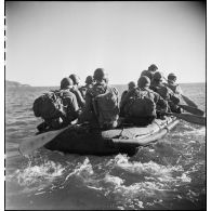 Des membres du groupe de commandos d'Afrique, devenu 5e bataillon de choc, à bord de rubber boats longent les falaises du Cap Nègre (reconstitution).