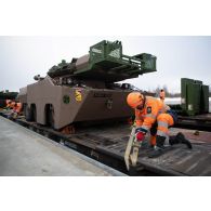 Un cheminot estonien prépare le déchargement d'un blindé à roues et canon rénovés AMX-10 RCR depuis un train en gare de Tapa, en Estonie.