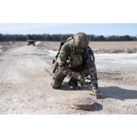 Un démineur du 1er régiment étranger de génie (REG) sonde le sol à proximité d'une mine d'exercice à Tapa, en Estonie.