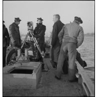 Caméramans du service cinématographique de la Marine (SCA/Marine) en tournage avec une caméra Debrie à bord d'un navire de la Marine nationale.