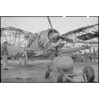 Chargement d'une bombe sur un bombardier en piqué Douglas SBD-5 Dauntless de l'aéronautique navale sur la base de Cognac.