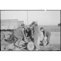 Des marins manipulent des bombes destinées à être chargées sur des bombardiers en piqué Douglas SBD-5 Dauntless de l'aéronautique navale sur la base de Cognac.