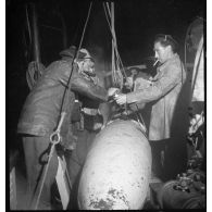 Au cours d'une mission de dragage de nuit, des marins fixent les filins sur un cochonnet de drague à bord d'un chalutier réquisitionné par la Marine nationale.