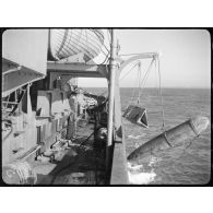 Mise à l'eau d'un cochonnet de drague et d'un prisme de divergence à bord d'un dragueur de mines.