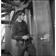 Portrait d'un quartier maître de 2e classe, membre d'équipage de l'aviso dragueur de mines Elan, pistolet au poing à bord du navire marchand allemand le Rostock.