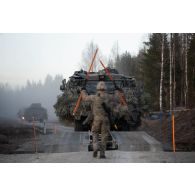 Un soldat britannique du Corps of Royal Engineers guide un véhicule de patrouille protégé (PPV) Mastiff 2 sur des travures pour le franchissement d'un cours d'eau à Tapa, en Estonie.