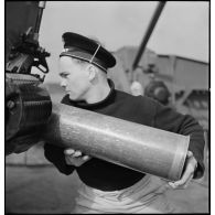 Chargement d'une pièce d'artillerie de 130 mm.