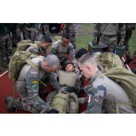 Des légionnaires de la 13e demi-brigade de la légion étrangère (DBLE) sanglent leur camarade sur un brancard au départ d'un parcours du combattant à Tapa, en Estonie.