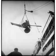 Chargement d'un canon antichars à bord d'un cargo.