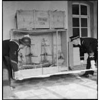 Ouverture de caisses contenant des objets du musée de la Marine, en provenance de l'exposition internationale de la technique de l'eau à Liège.