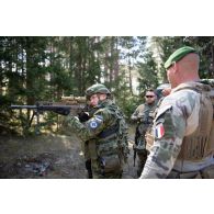 Un légionnaire du 1er régiment étranger de génie (REG) supervise la manipulation d'un fusil de précision FN SCAR-H PR par un réserviste estonien à Saaremaa, en Estonie.