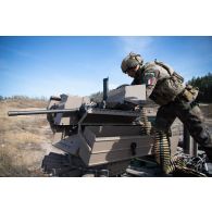 Un légionnaire de la 13e demi-brigade de la légion étrangère (DBLE) insère une bande de munitions de 12,7 mm dans la mitrailleuse Browning M2 d'un véhicule blindé multi-rôles (VBMR) Griffon à Tapa, en Estonie.