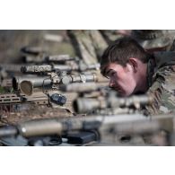 Un tireur d'élite américain de la 101st Airborne observe le terrain dans la lunette de son fusil de précision M110 semi automatic sniper system (SASS) pour une séance de tir à Tapa, en Estonie.