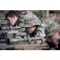 Des tireurs d'élite américains de la 101st Airborne observent le terrain dans la lunette de leur fusil de précision M110 semi automatic sniper system (SASS) pour une séance de tir à Tapa, en Estonie.