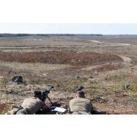 Un légionnaire de la 13e demi-brigade de la légion étrangère (DBLE) observe le terrain dans la lunette de visée de son fusil de précision PGM Hécate II aux côtés de son spotter pour une séance de tir à Tapa, en Estonie.