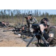 Des légionnaires de la 13e demi-brigade de la légion étrangère (DBLE) observent le terrain dans la lunette de visée de leur fusil de précision PGM Hécate II aux côtés de leur spotter pour une séance de tir à Tapa, en Estonie.