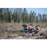 Un légionnaire de la 13e demi-brigade de la légion étrangère (DBLE) observe le terrain dans la lunette de visée de son fusil de précision PGM Hécate II aux côtés de son spotter pour une séance de tir à Tapa, en Estonie.