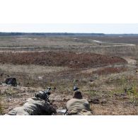 Un tireur d'élite américain de la 101e Airborne observe le terrain dans la lunette d'un fusil PGM Hécate II sous la supervision d'un spotter de la 13e demi-brigade de la légion étrangère (DBLE) à Tapa, en Estonie.