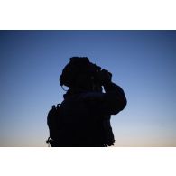 Un commando parachutiste (GCP) du 8e régiment parachutiste d'infanterie de marine (RPIMa) observe le terrain au moyen de ses jumelles de vision nocturne après avoir sauté sur Viitna, en Estonie.