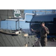 Un soldat britannique des Royal Marines guide un char Challenger 2 des Queen's Royal Hussars sur le port de Paldiski, en Estonie.