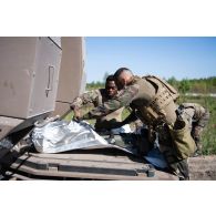 Des légionnaires de la 13e demi-brigade de la légion étrangère (DBLE) déballement un missile moyenne portée (MMP) à l'arrière d'un véhicule blindé multi-rôles (VBMR) Griffon à Tapa, en Estonie.