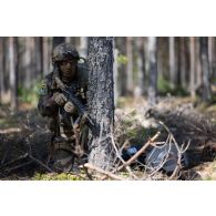 Un légionnaire de la 13e demi-brigade de la légion étrangère (DBLE) sécurise le périmètre à l'abri d'un arbre à Tapa, en Estonie.