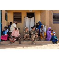 Les auxiliaires sanitaires Mathilde et Mélody discutent avec des patients pour une consultation au centre de santé d'Arlit, au Niger.