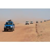 Des soldats nigériens escortent un convoi de ressortissants à bord de leur de pick-up sur la piste d'Arlit à Alguelal, au Niger.