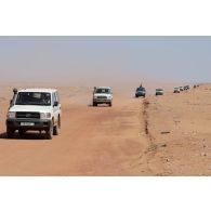 Des soldats nigériens escortent un convoi de ressortissants à bord de leur de pick-up sur la piste d'Arlit à Alguelal, au Niger.