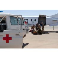 Le personnel de la 8e antenne chirurgicale aérotransportable (ACA) aide ses homologues belges et allemands pour l'évacuation d'un blessé depuis un avion Beechcraft 1900 Beechliner sud-africain à Niamey, au Niger.