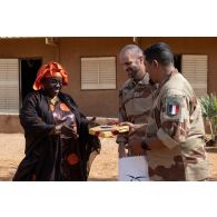 L'aumônier Soufiane offre un cadeau à l'inspectrice de l'école Garbado aux côtés du colonel Grégoire Servent à Niamey, au Niger.