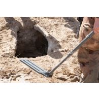 Le sergent Aurélien du 3e régiment du génie (RG) inspecte un puits au moyen d'un détecteur de mines dans le secteur sud d'Afonda, au Niger.