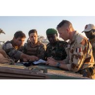 Le capitaine Nicolas du groupement d'aide à l'engagement blindé (GAEB) de la 7e brigade blindée (BB) dirige un briefing auprès des lieutenants-colonels Ousseini et Jean-Marc dans le secteur de Tingara, au Niger.