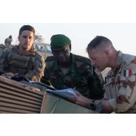 Le capitaine Nicolas du groupement d'aide à l'engagement blindé (GAEB) de la 7e brigade blindée (BB) dirige un briefing auprès des lieutenants-colonels Ousseini et Jean-Marc dans le secteur de Tingara, au Niger.