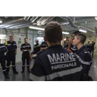 Des soldats de l'équipe d'intervention participent à un briefing au terme d'un exercice incendie à bord du porte-hélicoptères amphibie (PHA) Tonnerre en mer Méditerranée.