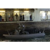 Des soldats britanniques des Royal marines embarquent à bord de leur zodiac dans le radier du porte-hélicoptères amphibie (PHA) Tonnerre, en mer Méditerranée.