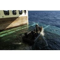 Des soldats britanniques des Royal marines manoeuvrent pour le déradiage de leur zodiac dans le radier du porte-hélicoptères amphibie (PHA) Tonnerre, en mer Méditerranée.