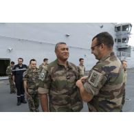 Le colonel Jean-Hugues Delcourt du régiment d'infanterie-chars de marine (RIMC) remet un brevet de qualification à un marsouin à bord du porte-hélicoptères amphibie (PHA) Tonnerre, en mer Méditerranée.