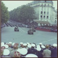 Le général de brigade Louis Pitel, adjoint au gouverneur militaire de Paris (GMP) commandant la 1re région militaire (1re RM), ouvre le défilé motorisé devant la tribune des Dames lors de la cérémonie militaire du 14 juillet 1979, suivi du défilé monté de motards de l'escadron motocycliste de la gendarmerie.