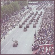 Vue aérienne du défilé motorisé devant l'Ecole militaire. Passage du drapeau et sa garde du 1er régiment de hussards parachutistes (1er RHP) sur Jeep Hotchkiss M201, lors de la cérémonie du 14 juillet 1977.