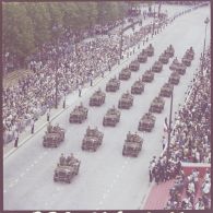 Vue aérienne du défilé motorisé devant l'Ecole militaire. Passage du drapeau et sa garde du 1er régiment de hussards parachutistes (1er RHP) sur Jeep Hotchkiss M201, lors de la cérémonie du 14 juillet 1977.