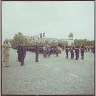 Valéry Giscard d’Estaing, président de la République, salue le drapeau de la Garde républicaine de Paris (GRP), lors de la cérémonie du 14 juillet 1977.