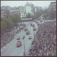 Vue aérienne du défilé motorisé. Passage du drapeau et sa garde et de véhicules de la brigade des sapeurs-pompiers de Paris (BSPP), lors de la cérémonie du 14 juillet 1977.