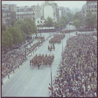 Vue aérienne du défilé monté. Passage de la fanfare suivie de l'étendard et sa garde du régiment de cavalerie de la Garde républicaine de Paris (RCGR), lors de la cérémonie du 14 juillet 1977.