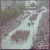 Vue aérienne du défilé monté. Passage de la fanfare suivie de l'étendard et sa garde du régiment de cavalerie de la Garde républicaine de Paris (RCGR), lors de la cérémonie du 14 juillet 1977.