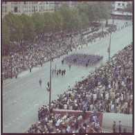 Vue aérienne du défilé à pied. Passage du drapeau et sa garde de l'école interarmées des personnels militaires féminins (EIPFM) de Caen, lors de la cérémonie du 14 juillet 1977.