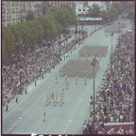 Vue aérienne du défilé à pied. Passage du drapeau et sa garde de l'école nationale des sous-officiers d’active (ENSOA), lors de la cérémonie du 14 juillet 1977.